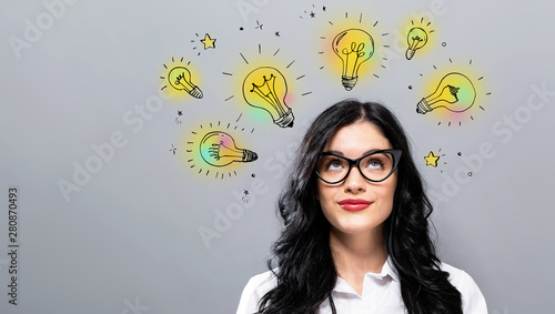 Fotografía Idea light bulbs with young businesswoman in a thoughtful face