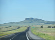 Endless ribbon of blacktop heading towards a mesa butte in New Mexico