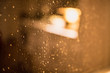 Regentropfen an einer Fensterscheibe bei gemütlichem Licht