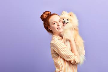 Wall Mural - pleasant girl embracing the pet, woman has addopted nice dog. close up portrait, isolated blue background studio shot.closeness, affection