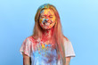 © alfa27 - funny playful blonde girl enjoying holi festival, getting pleasure from holiday. isolated blue background, studio shot