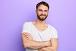 © the faces - young strong caucasian man standing with crossed arms, looking at the camera,muscular guy expresses positive feeling . close up portrait. studio shot, body care, health care