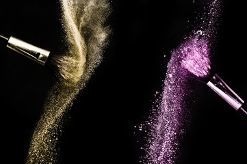 Cosmetic brush with purple and golden cosmetic powder spreading for makeup artist and graphic design in black background