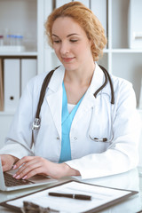 Wall Mural - Doctor woman at work. Physician typing on laptop computer. Medicine, healthcare concept