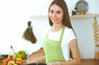 © rogerphoto - Young happy woman cooking soup in the kitchen. Healthy meal, lifestyle and culinary concept. Smiling student girl preparing vegetarian meal at home