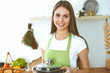 © rogerphoto - Young happy woman cooking soup in the kitchen. Healthy meal, lifestyle and culinary concept. Smiling student girl preparing vegetarian meal at home
