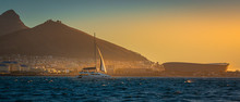 Sailboat Cruises Cape Town, South Africa With Table Top Mountain And Lions Head At Sunset