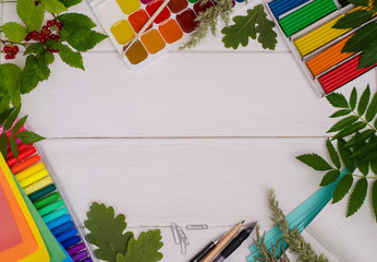 Back to school: composition of school supplies with a copy space on a white wooden background