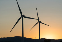 Wind Turbines, Green Energy Windmills Silhouetted Against Golden Sunset Sky, Northern California Wine Country. 