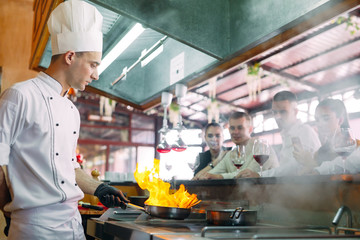 The chef prepares food in front of the visitors in the restaurant