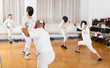 © JackF - Adults and teens wearing fencing uniform practicing with foil