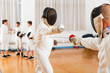 © JackF - Adults and teens wearing fencing uniform practicing with foil