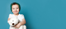 Little Boy In Green Hat Hold Polar Bear Toy Smiling. International Day Of Polar Bear Concept