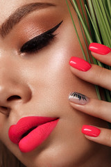 Beautiful young woman with bright makeup and neon pink nails. Beauty face. Photo taken in the studio