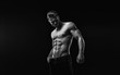 © KDdesignphoto - Black and white. Muscular model sports young man on dark background. Fashion portrait of strong brutal guy with a modern trendy hairstyle. Sexy torso. Male flexing his muscles.