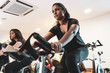 Fit people working out at spinning class in gym