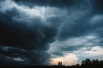 dramatic cloudscape. sunny light through dark heavy thunderstorm clouds before rain. overcast rainy 