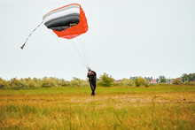 Skydiver Lands On Green Field