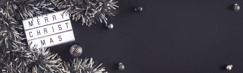 Wall Mural - Merry christmas and happy new year lightbox on black table background.top view of tinsel,ball decorate on tabletop.holiday celebration greeting card.banner panoramic for display of design.