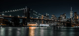 Fototapeta Nowy Jork - Brooklyn Bridge with tranquil waters and the city in the background
