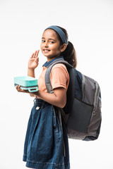 Indian girl in school uniform, standing isolated over white background ready to leave