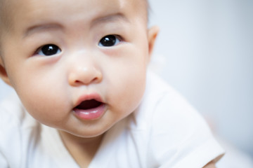 Asian baby happy in the room.Asian baby girl lying down on bed .