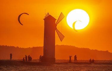 Wall Mural - lighthouse in the shape of a windmill in swinoujscie in poland during sunset