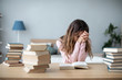 © BestForYou - Tired student girl at the table with a lot of books. Back to school.