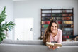 © BestForYou - Young beautiful woman reading book relaxing in living room.
