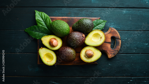 Fotomural Fresh avocado with leaves on a black background