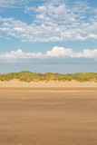 Fototapeta Sawanna - Looking back over the sandy beach towards the marram grass covered sand dunes, at Formby in Merseyside