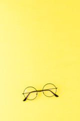 Wall Mural - Fashionable eyeglasses on yellow background with copyspace