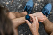 © Maridav - Fit man checking smart watch wearable technology sport smartwatch on fitness run walk outside. Top view from above with running shoes in street.