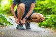 © Maridav - Running shoes sports smartwatch man tying shoe laces. Male fitness runner getting ready to jog in spring autumn jogging outdoor wearing technology wearable smart watch.
