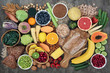 Leinwandbild Motiv High fibre super food with whole grain bread loaf and rolls, fruit, vegetables, whole wheat pasta, cereals, seeds and nuts. Foods omega 3, anthocyanins, antioxidants and vitamins. Top view.
