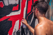 Graffiti Artist Painting A Wall In The Street