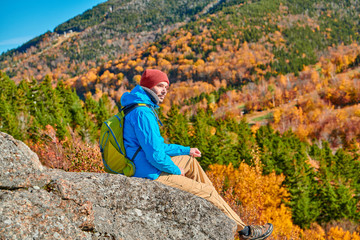 Wall Mural - Backpacker man hiking at Artist's Bluff in autumn. Fall colours in Franconia Notch State Park. White Mountain National Forest, New Hampshire, USA