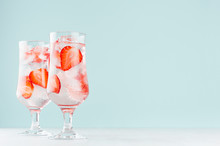 Strawberry Water With Red Fruit Slices, Ice Cubes, Sparkling Water In Two Misted Glasses In Modern Mint Color Interior.