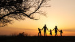 © alex_marina - Silhouettes of happy family walking together in the meadow during sunset