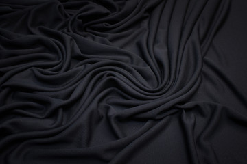 Cotton knit fabric in black in a beautiful layout. Texture, background, pattern.