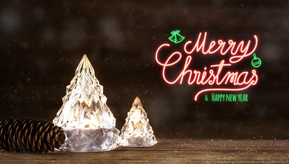 Merry Christmas and happy new year neon sign with modern glass Christmas tree with lights on dark wood table with wall for celebrate holiday greeting card background.