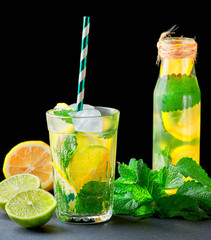 refreshing drink lemonade with lemons, mint leaves, ice cubes and lime in a glass