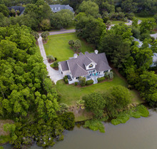 Aerial View Of Expensive Waterfront Home On Wooded Lot.