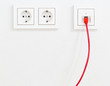 © Shawn Hempel - Red network cable in wall outlet for office or private home lan ethernet connection with power outlets flat view on white plaster wall