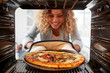 View Looking Out From Inside Oven As Woman Cooks Fresh Pizza