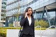 © Monkey Business - Businesswoman Commuting To Work Talking On Mobile Phone Outside Modern Office Building