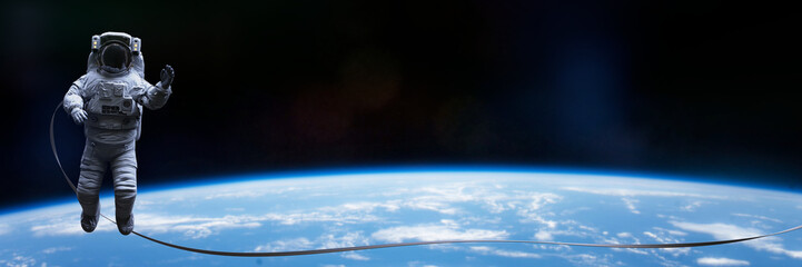 Wall Mural - astronaut with safety tether performing a spacewalk in empty space