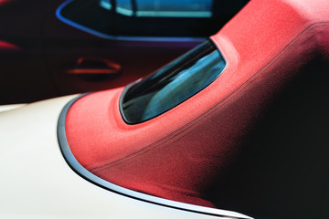 Cabriolet with a red roof in the parking lot