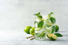Fresh Mojito Cocktail With Lime And Mint In Glass On Concrete Background. Cold Refreshing Drink. Selective Focus.