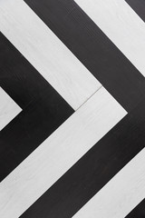 Wall Mural - top view of black and white wooden herringbone floor background texture, Looks like direction arrow symbol.